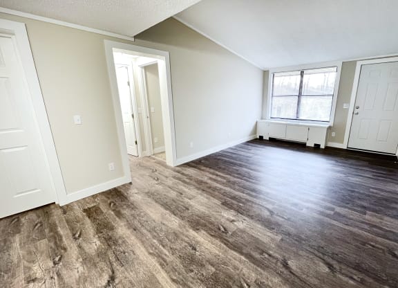 an empty living room with white walls and wood floors at Wentworth Estates Apartments, Florence, KY