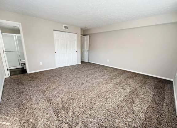 an empty living room with carpeting and white walls at Revere Village Apartments, Centerville