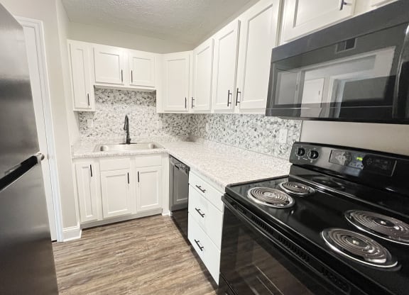 a kitchen with black appliances and white cabinets at 450 on Keeneland Apartments, Kentucky