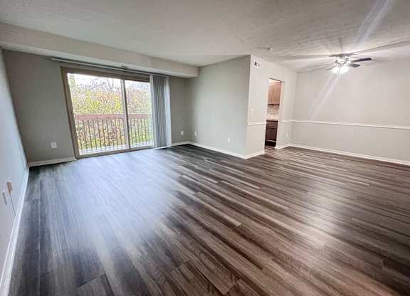 A room with wooden flooring and a sliding glass door.