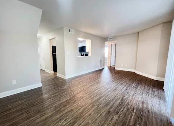 A room with wooden flooring and white walls.