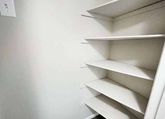 a small closet with white shelves and a white wall at Revere Village Apartments, Centerville, Ohio