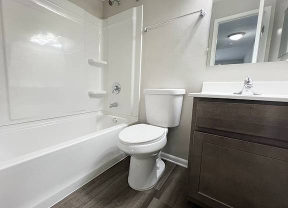 a bathroom with a toilet and a tub and a sink at Revere Village Apartments, Centerville