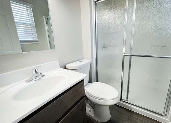 an empty bathroom with a shower toilet and sink at Revere Village Apartments, Centerville, OH, 45458