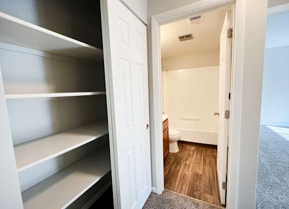 A white door is open to a small bathroom.