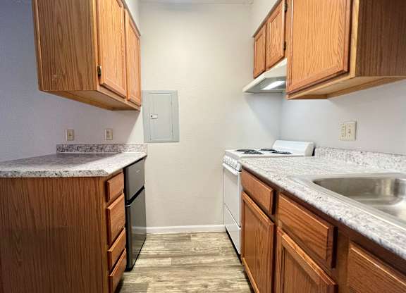 A kitchen with wooden cabinets and a granite countertop.