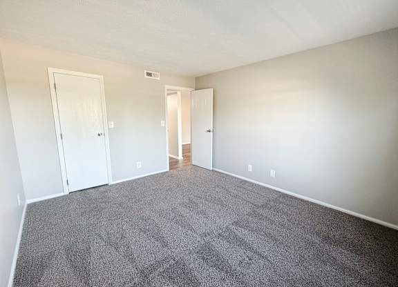 A room with grey carpet and white walls.