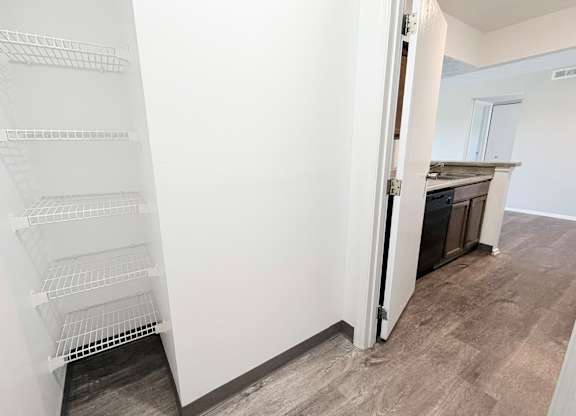 A white shelving unit in a room with a grey floor.
