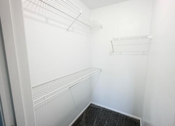 A white empty pantry with a black floor.