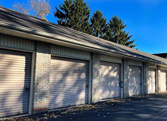A long building with a grey roof and white garage doors.