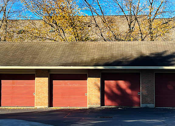 A building with red garage doors and a grey roof.