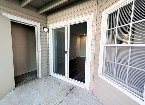 A patio area with a sliding glass door and a window.