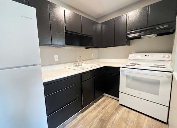 A white fridge sits next to a white oven in a kitchen.