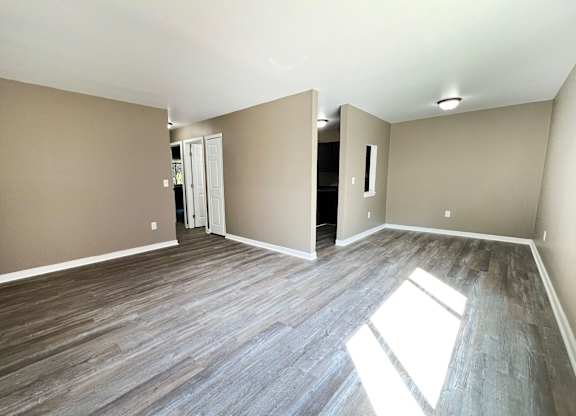 A room with wooden flooring and a white door.