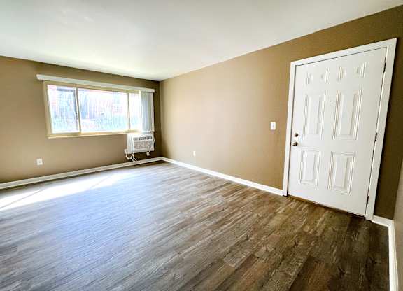 A room with a white door and a window with blinds.