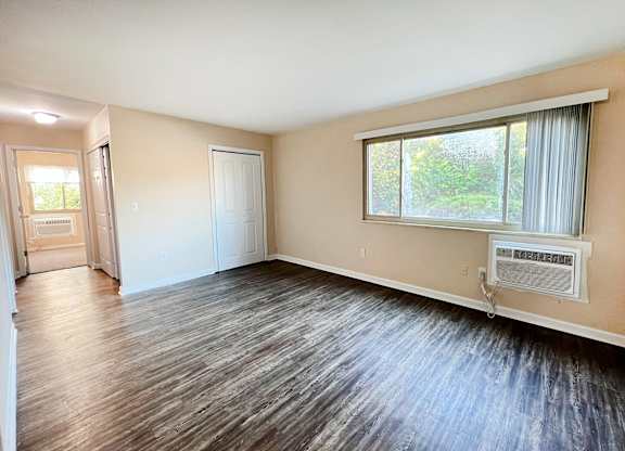 A room with a window and a wall-mounted air conditioner.