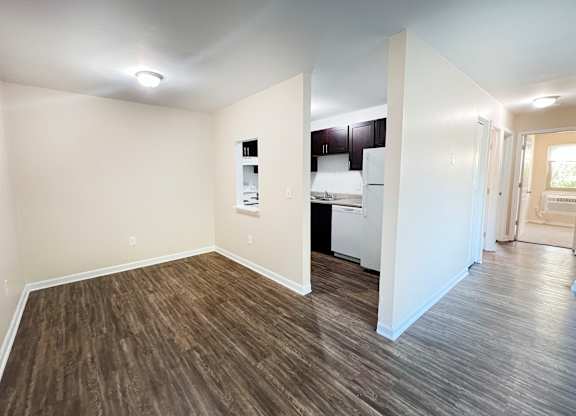 A room with wooden flooring and white walls.