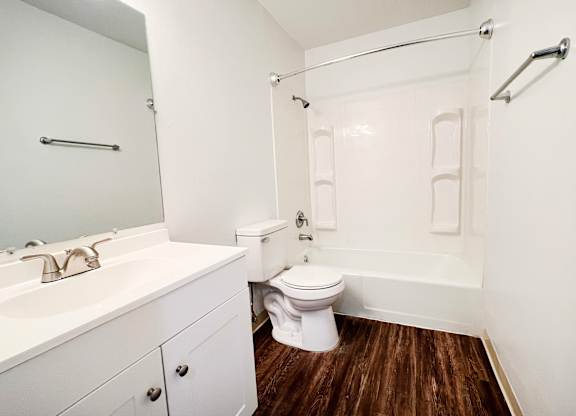 A white bathroom with a toilet, sink, and bathtub.