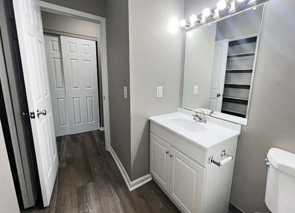A white bathroom with a vanity and a white tub.