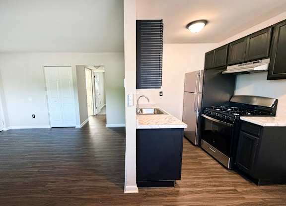 A kitchen with black cabinets and a white countertop.