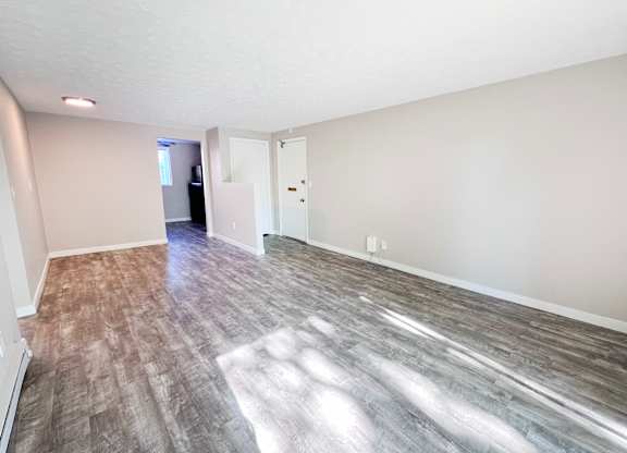 A room with a wooden floor and white walls.