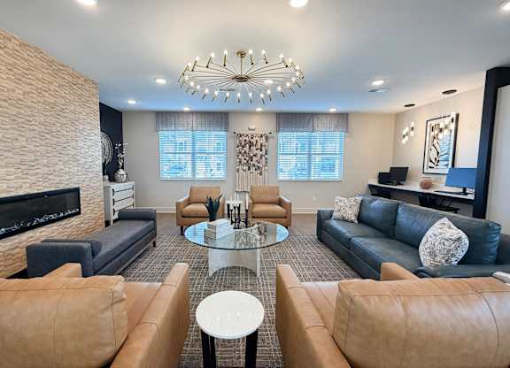 A modern living room with a fireplace and a glass coffee table.