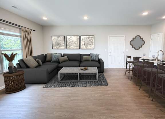A living room with a grey sofa and a glass coffee table.