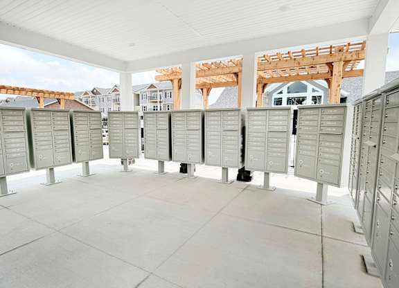 Covered mailbox area with multiple parcel lockers at The Meridian on 32 Apartments, Batavia