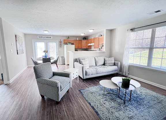 A living room with a grey armchair and a white sofa.