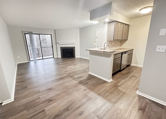 an empty living room with a kitchen and a fireplace  at Deercross Apartments, Cincinnati, 45236