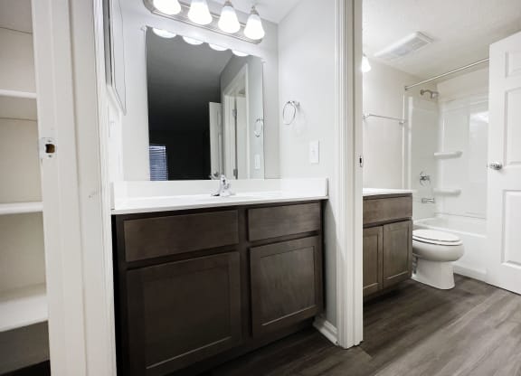a bathroom with a sink and a toilet and a mirror  at Deercross Apartments, Cincinnati, 45236
