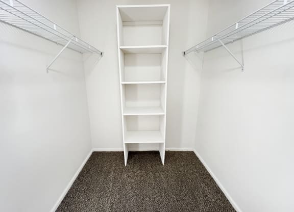 an empty closet in a room with white walls and shelves  at Deercross Apartments, Cincinnati