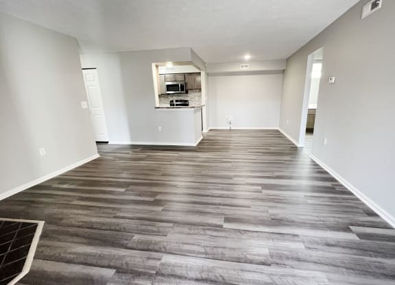 an empty living room with wood flooring and a kitchen  at Deercross Apartments, Cincinnati
