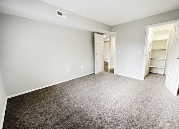 an empty bedroom with carpeting and a closet  at Deercross Apartments, Ohio