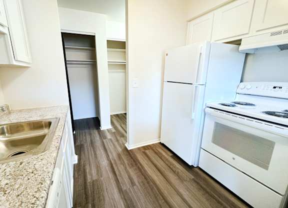 a renovated kitchen with white appliances and wood flooring at Four Worlds Apartments, Ohio