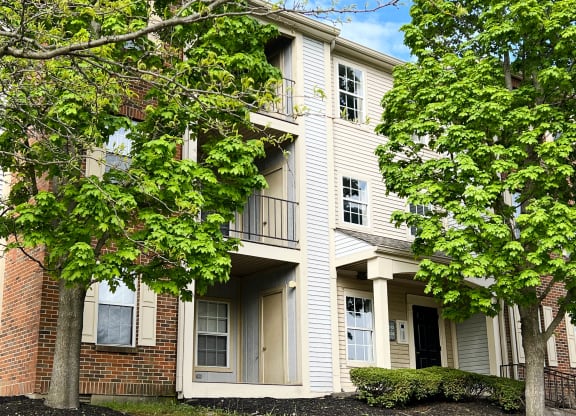 a picture of a three story apartment building with trees in front of it  at Woodhills Apartments, West Carrollton, OH, 45449