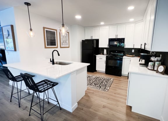 a kitchen with white cabinets and black appliances at Indian Lookout Apartments, Cincinnati, OH