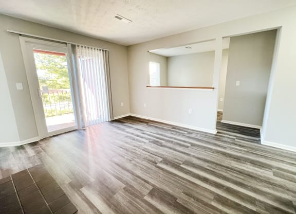 an empty living room with wood flooring and sliding glass doors  at Deercross Apartments, Cincinnati