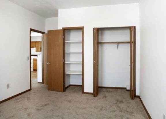 A room with two open doors and a carpet on the floor.
