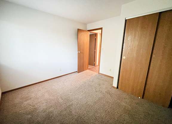 a bedroom with a carpeted floor and a door to a closet at Forest Creek Apartments, Middletown, 45044