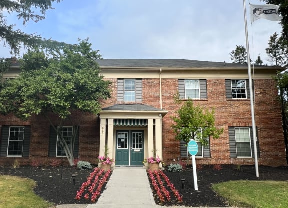 a brick building with a green door and a street sign