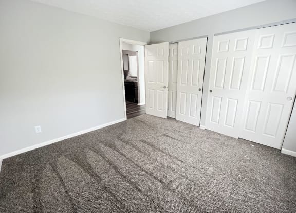 an empty bedroom with carpet and white doors at Fox Run Apartments, Cincinnati, Ohio, 45236