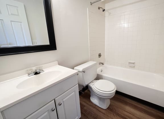 an empty bathroom with a toilet and a tub and a sink  at Crown Station Apartments, Amelia, OH, 45102