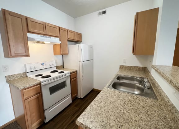 a kitchen with white appliances and granite counter tops  at Brookfield Village Apartments, Grove City
