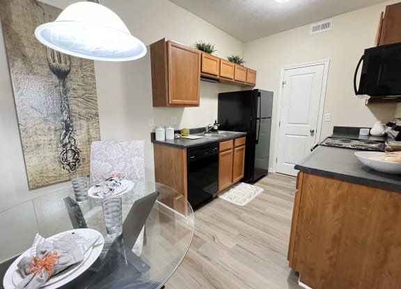 an open kitchen and dining room with a glass table and chairs at Residences at Northgate Crossing, Ohio, 43235