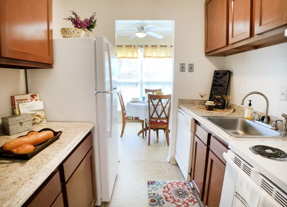 a kitchen with wooden cabinets and a sink and a refrigerator at Timber Ridge Apartments, Cincinnati