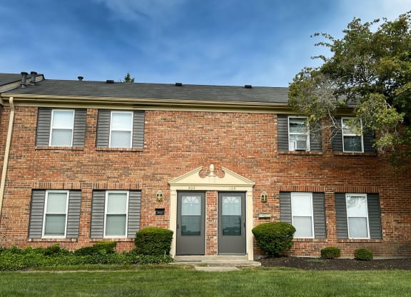 the front of a brick building with a blue door at Revere Village Apartments, Ohio, 45458