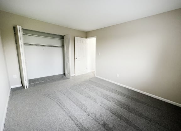 an empty bedroom with a closet and an open door at Wentworth Estates Apartments, Florence, KY