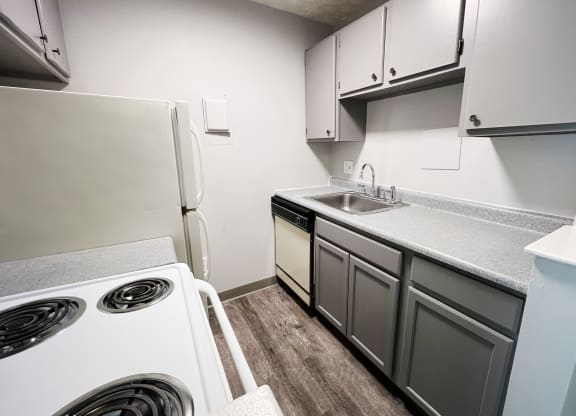 a kitchen with white cabinets and white appliances  at Summit East - A Senior Community, Cincinnati, OH, 45237