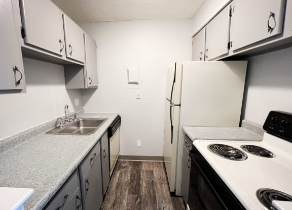 a kitchen with white cabinets and white appliances  at Summit East - A Senior Community, Cincinnati, Ohio